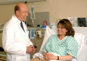 A doctor visits with a female patient in a hospital bed