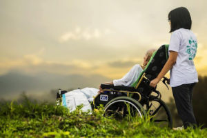 An elderly person in hospice care is shown the sunset