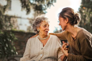 A young woman smiles at an elderly woman